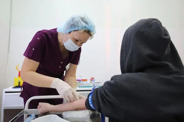 Медицинская сестра берет кровь для анализа у пациента в процедурном кабинете в детской поликлинике в Волгограде