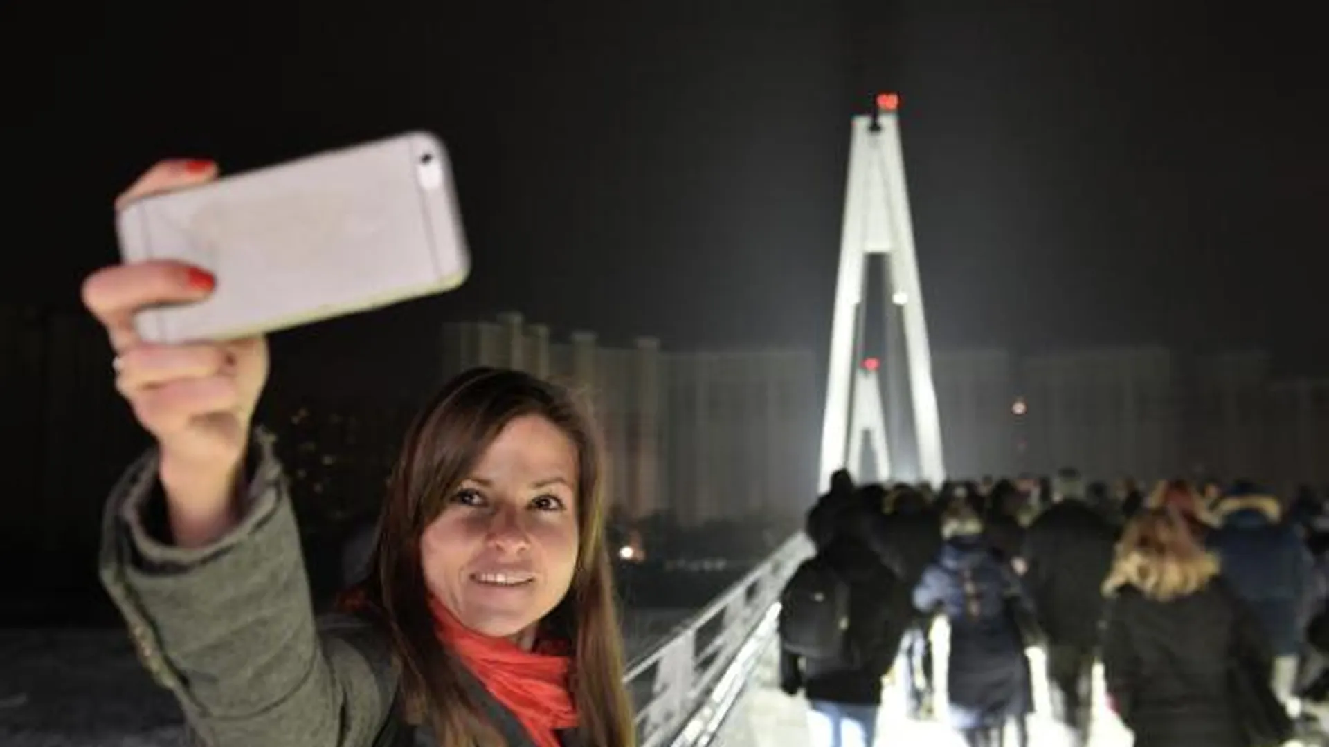 Девушка фотографируется на фоне Павшинского пешеходного моста в Московской области