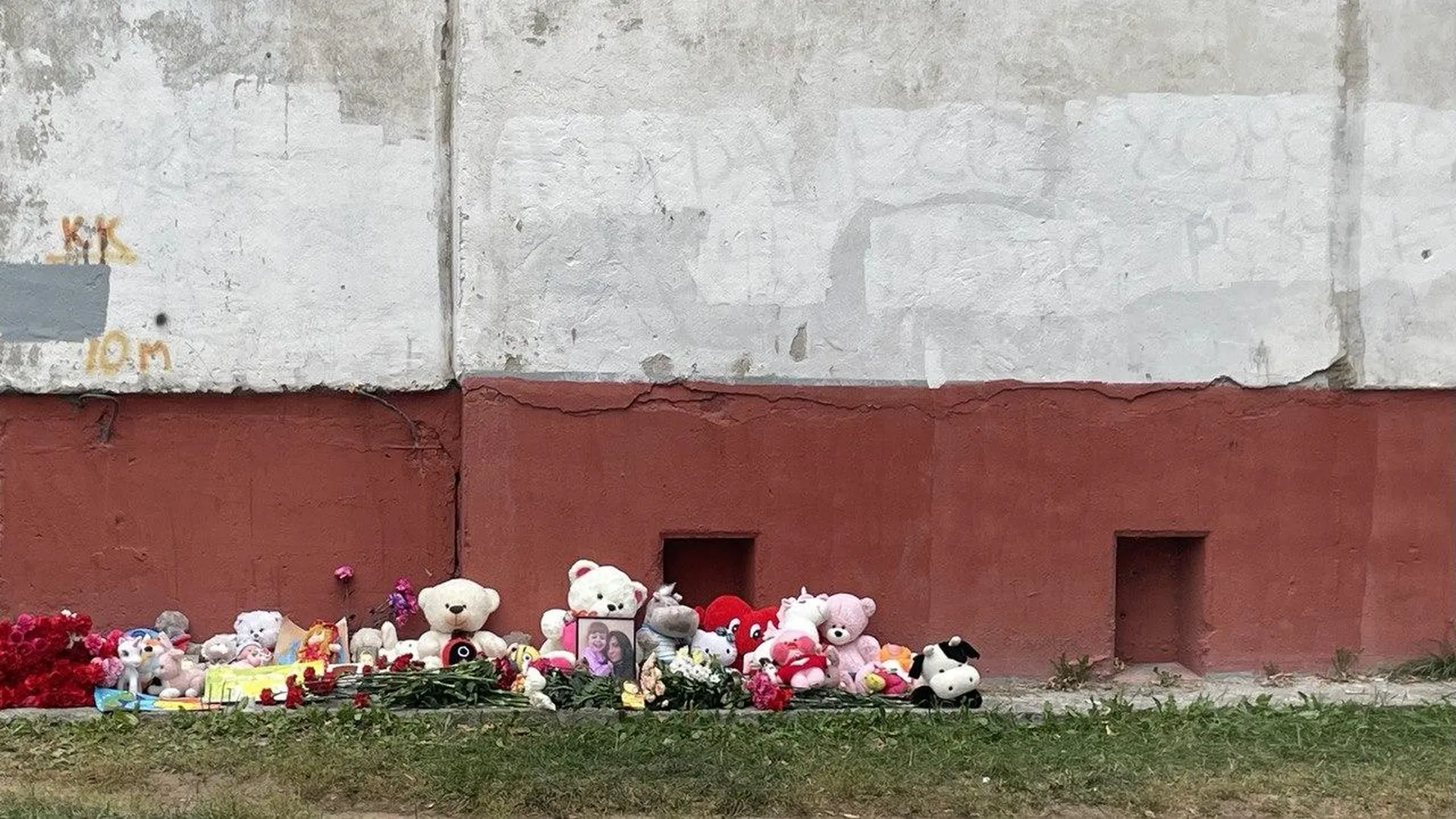 Родные погибших под завалами в Балашихе женщины с дочкой возложили цветы к стихийному мемориалу