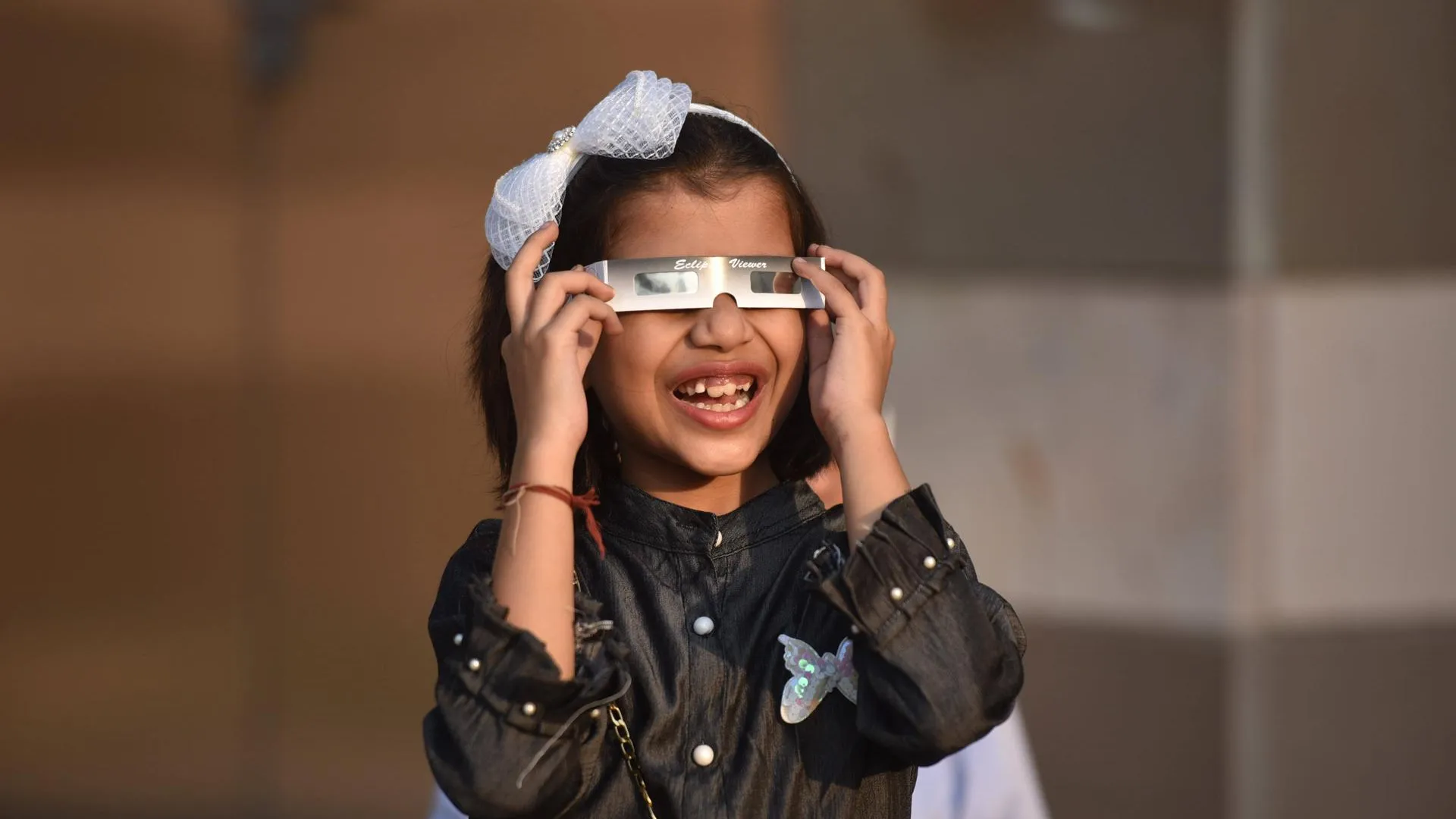 Девочка из Индии наблюдает за солнечным затмением. Фото: IMAGO / Hindustan Times