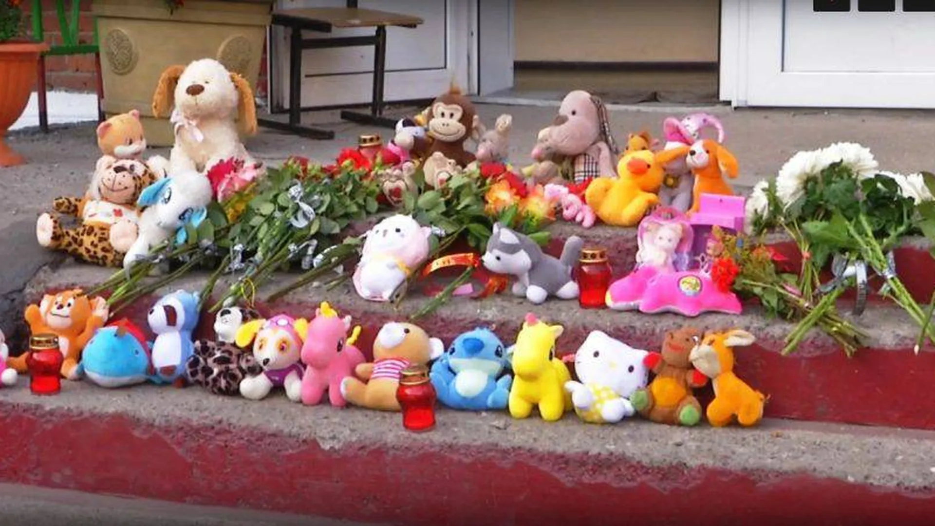 Жители Киселевска принесли цветы и игрушки к школе, где учились убитые девочки