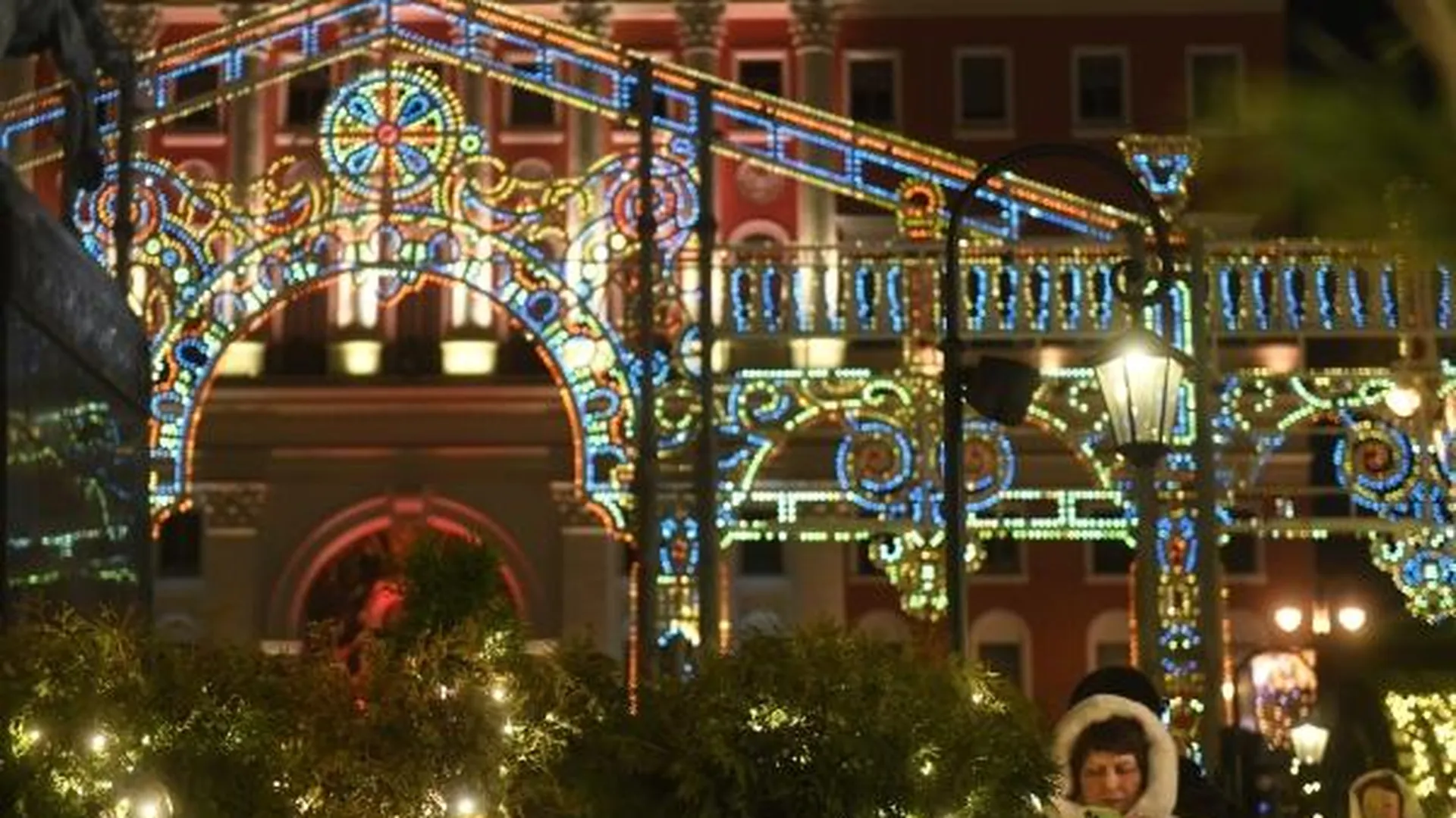 Люди отдыхают на площадке зимнего фестиваля «Путешествие в Рождество» у здания мэрии на Тверской площади Москвы