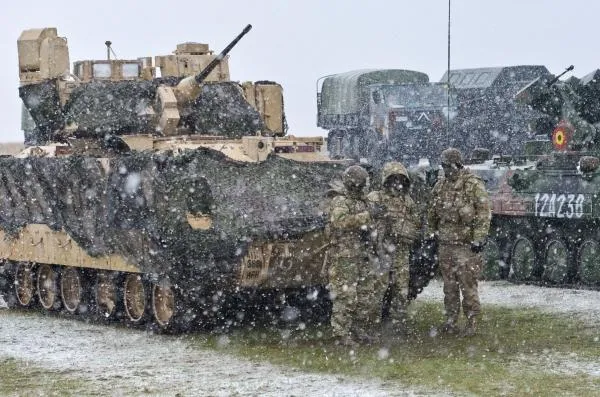 Военнослужащие возле американской боевой машины пехоты M2 Bradley во время совместных учений армий США и Румынии в рамках операции «Атлантическая решимость»