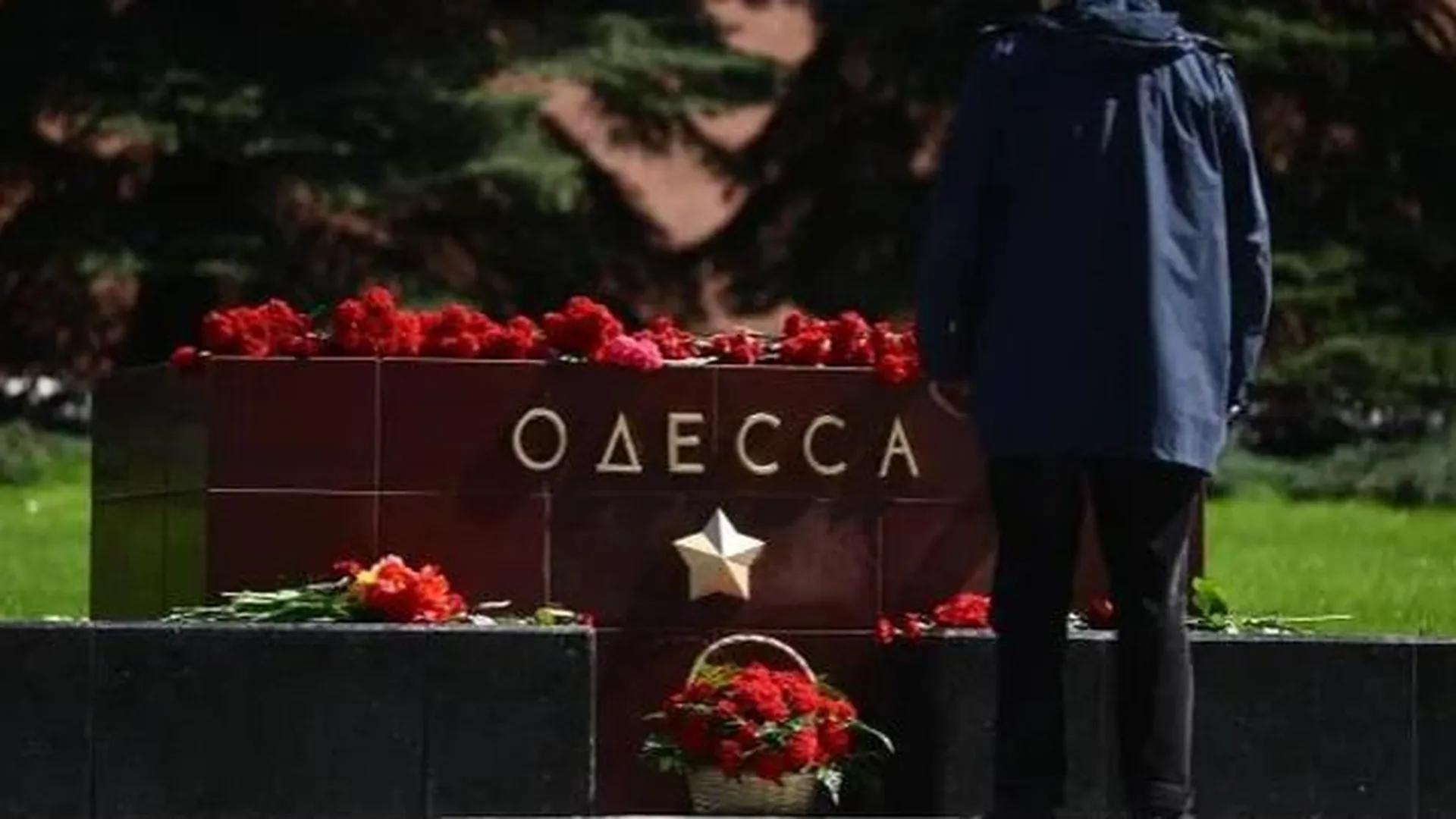 Мужчина возлагает цветы на аллее городов-героев и воинской славы в Москве в память о жертвах трагедии в Доме профсоюзов в Одессе