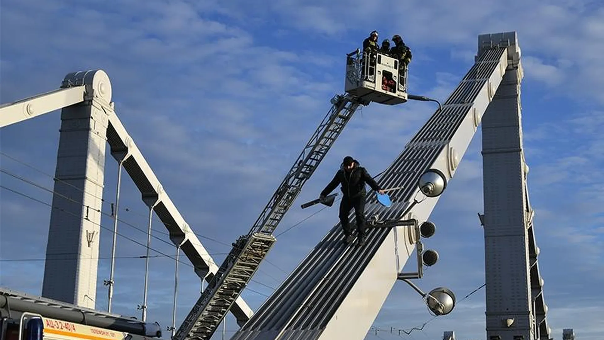 Хулигана, который влез на опору Крымского моста, силком доставили в полицию