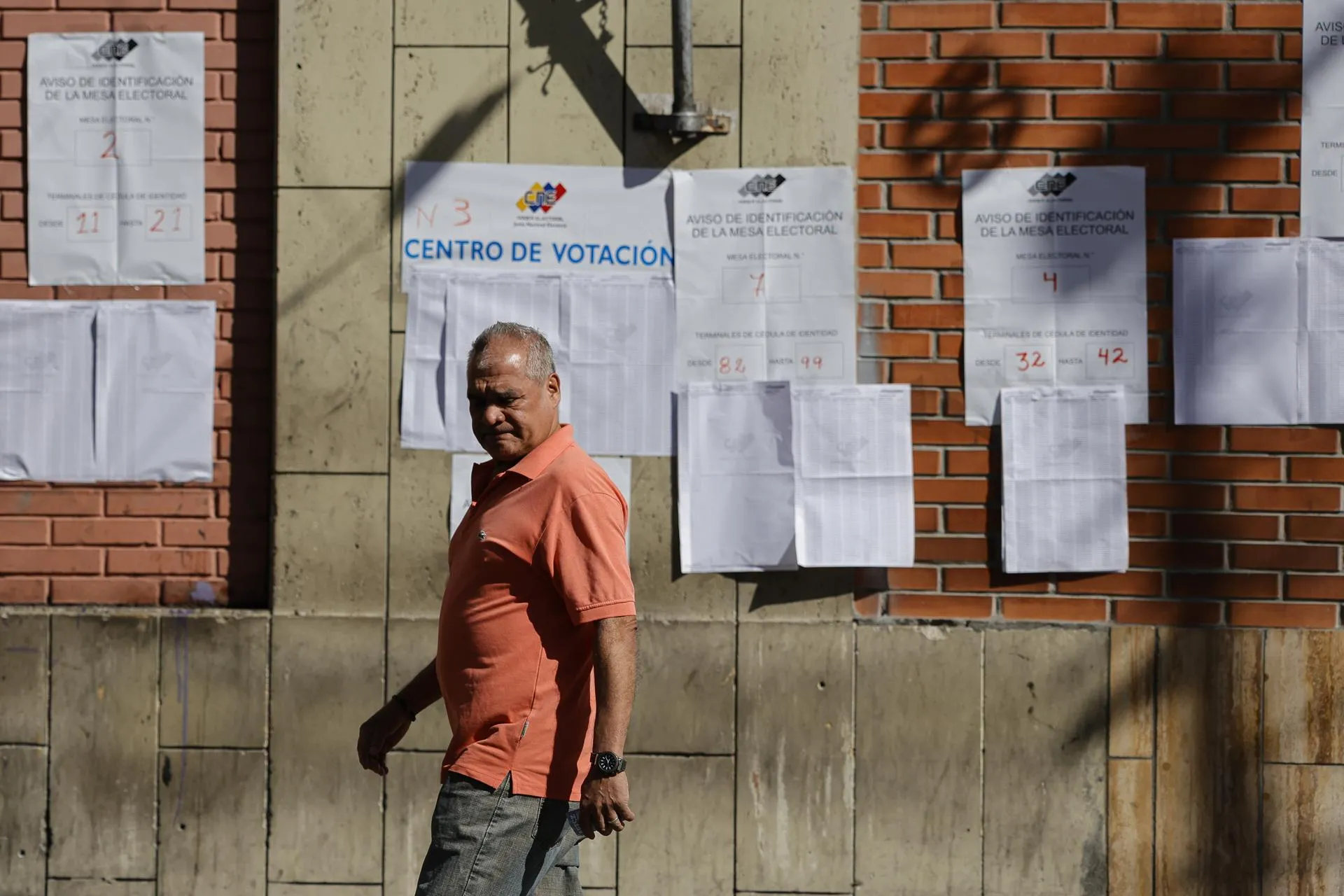 Надпись на плакате за мужчиной «Центр голосования» / Фото: Jesus Vargas