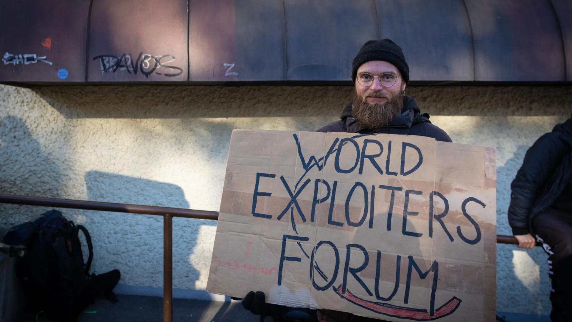 Протестующий в Давосе. Надпись на плакате: «Форум мировых эксплуататоров». Фото: Andy Barton/Keystone Press Agency
