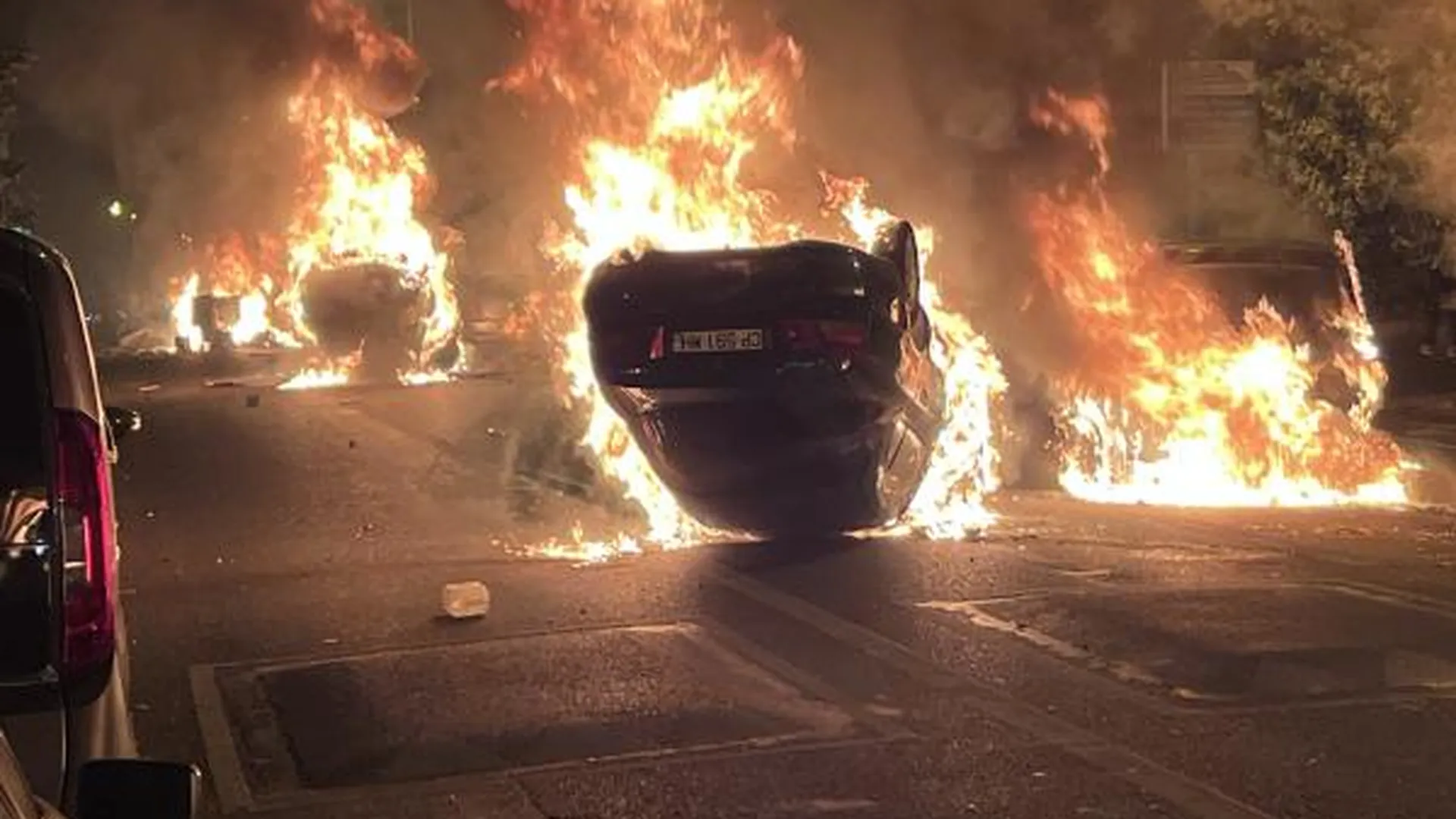 Горящие автомобили во время беспорядков в Нантере — административном центре департамента О-де-Сен, одном из крупнейших пригородов Парижа, 29 июня 2023 года