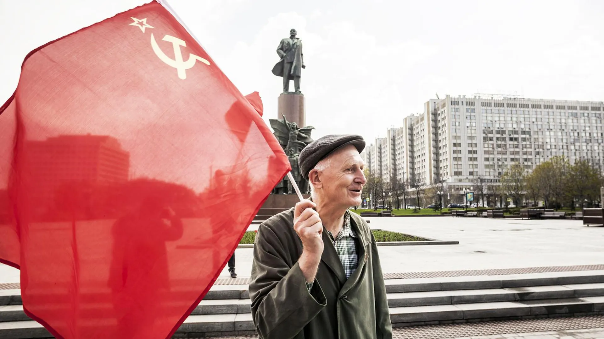 Мужчина с советским флагом на фоне памятника Ленину, Москва, 1 мая 2018 года. Фото: Celestino Arce