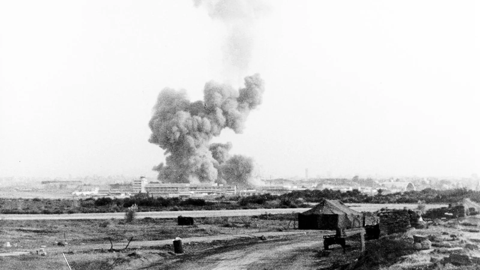 Облако дыма над разбомбленными американскими казармами в международном аэропорту Бейрута, где погибли более 200 морских пехотинцев США, октябрь 1983 года
