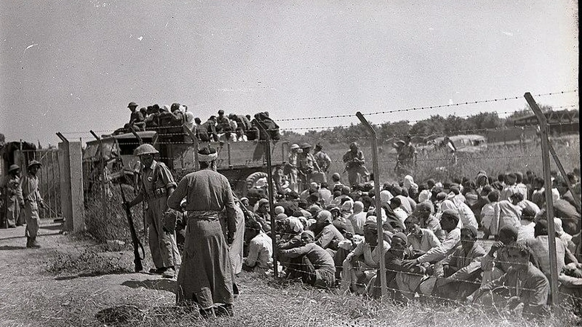 Мужчины-арабы за забором из колючей проволоки перед высылкой. Рамла, 10 июля 1948 года
