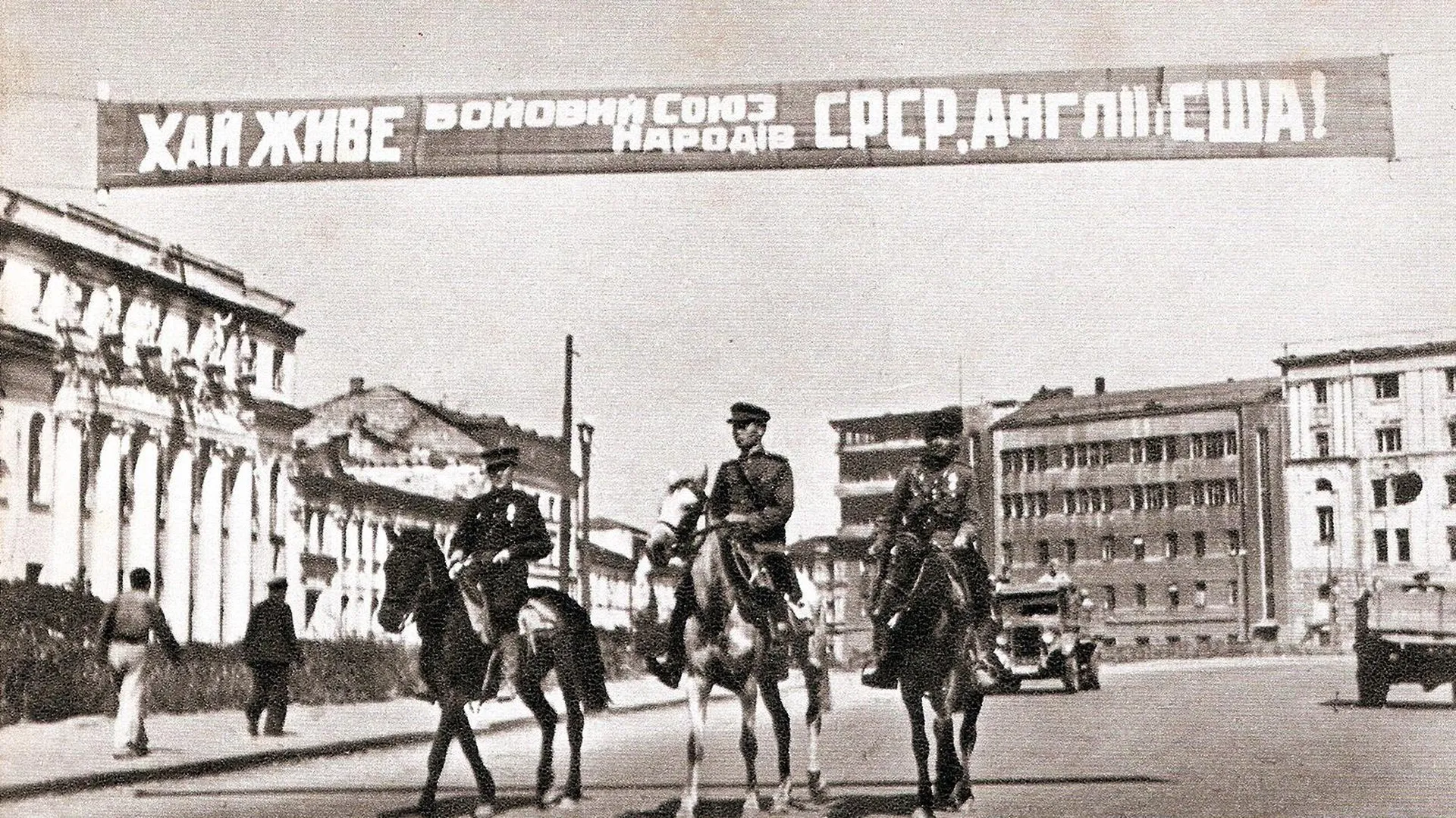 Советские военные на Украине, над ними транспарант с надписью «Да здравствует боевой союз народов СССР, Англии и США!», 1943 год