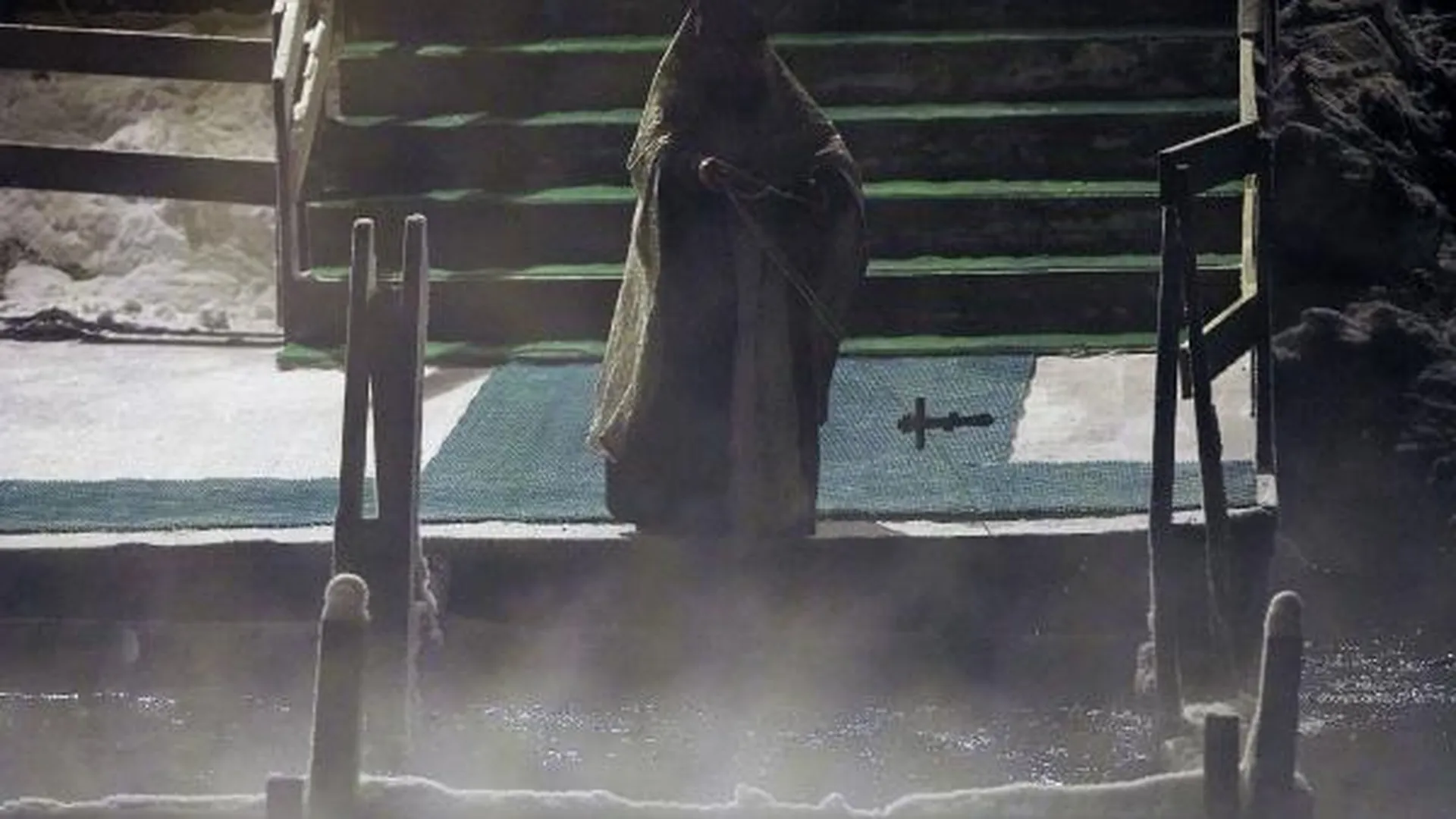 Священнослужитель проводит обряд крещения и освящения иордани на реке Истре неподалеку от Свято-Воскресенского Ново-Иерусалимского ставропигиального мужского монастыря в Истре