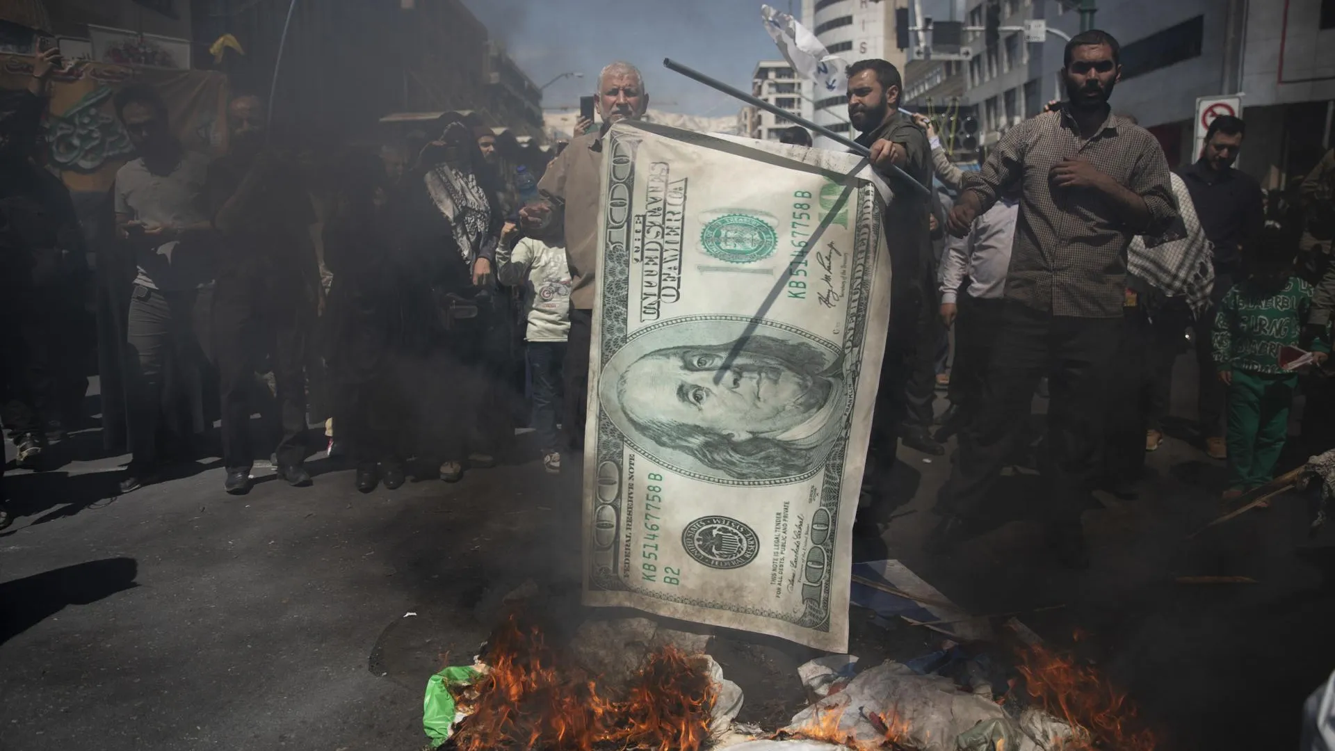 Протестующие жгут изображение доллара на акции памяти жертв удара Израиля по консульству Ирана в Сирии