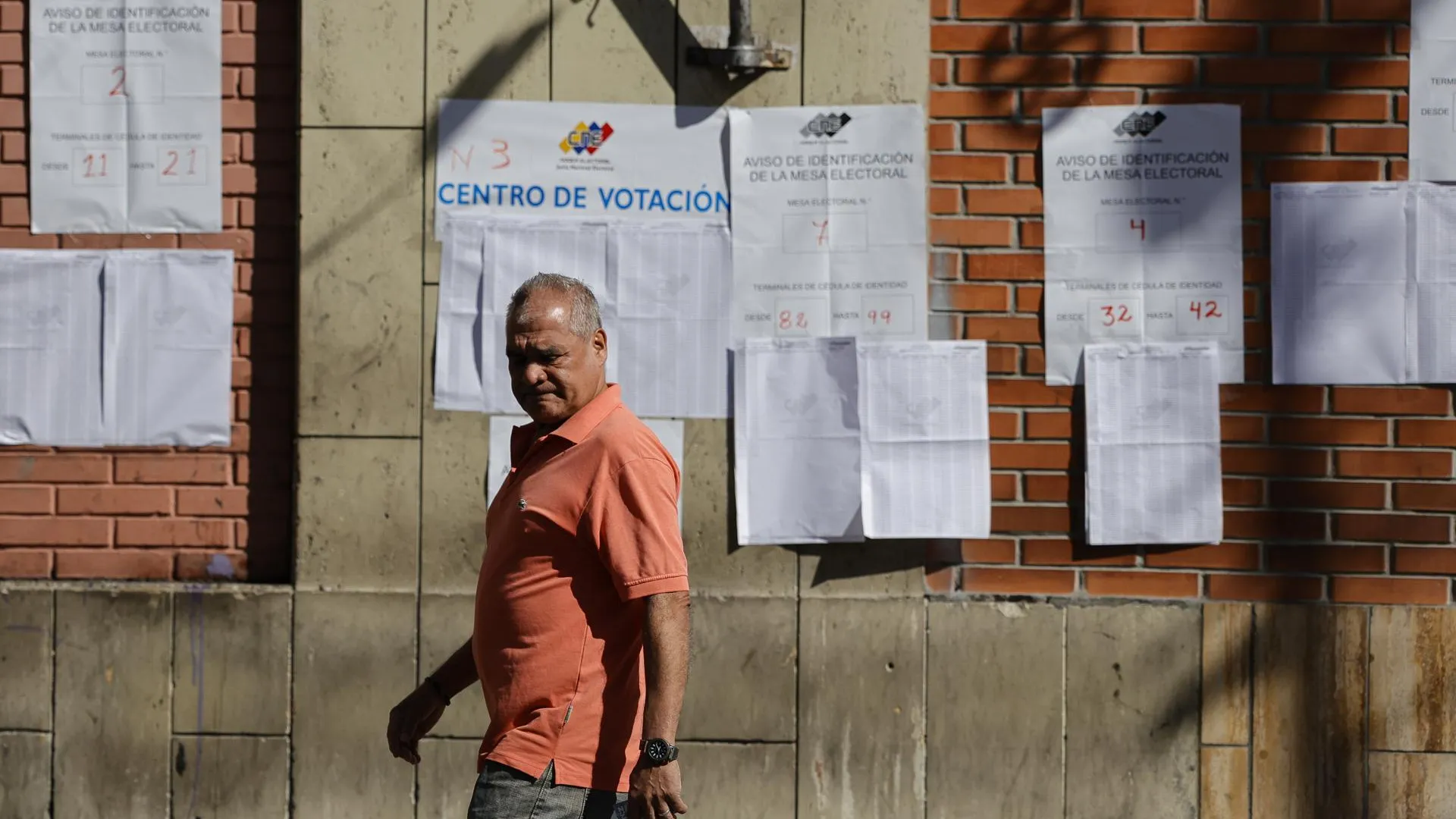 Надпись на плакате за мужчиной «Центр голосования» / Фото: Jesus Vargas