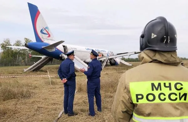Сотрудники спасательных служб на месте аварийной посадки самолета