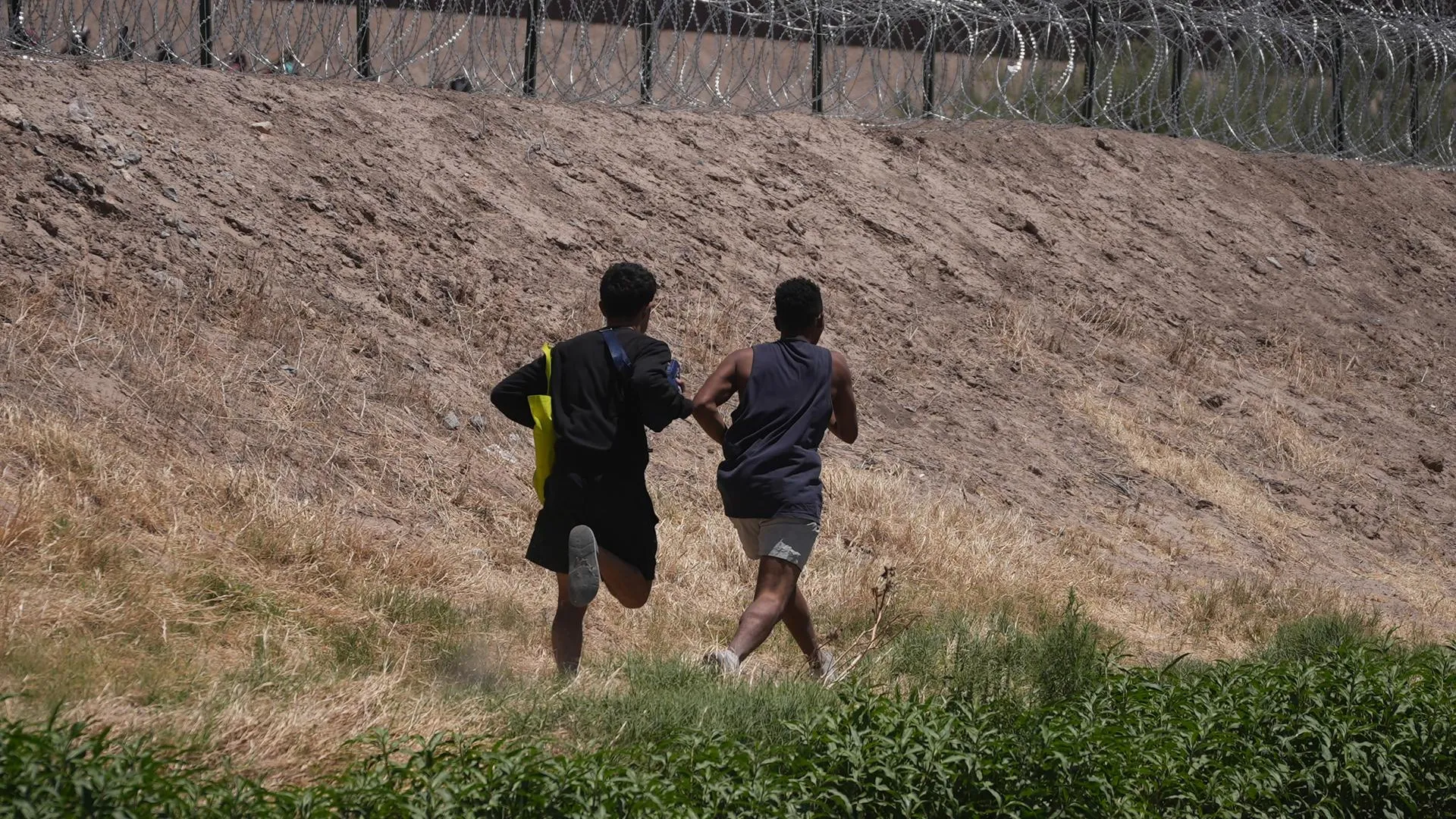 Два мигранта из Венесуэлы бегут к мексиканско-американской границе. Фото: Rafael Hernandez